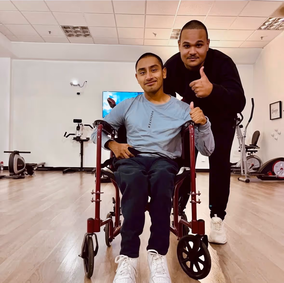 Client in wheelchair poses with Jomilson Alvarez in Saint Christopher's FItness